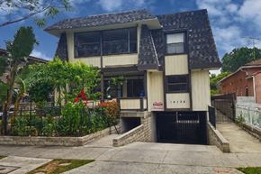 Van Nuys apartment for rent - the front of a house with a driveway and a black gate