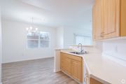 San Ramon apartment for rent - A kitchen with wooden cabinets and a white countertop and dining area with chandelier at Cornerstone at Gale Ranch Apartments, San Ramon