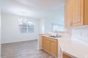 San Ramon apartment for rent - A kitchen with wooden cabinets and a white countertop and dining area with chandelier at Cornerstone at Gale Ranch Apartments, San Ramon