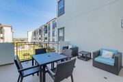 San Ramon apartment for rent - A balcony with a table and chairs overlooking a pool at Deer Creek Senior Apartments in San Ramon, CA 94582