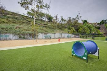 A dog park with a large blue dog kennel and a red fire hydrant