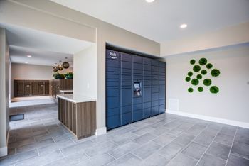 A modern lobby with a reception desk and a large wall art.