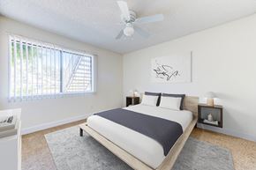Redlands apartment for rent - a bedroom with a bed, window, and a ceiling fan at Redlands Park Apts, California
