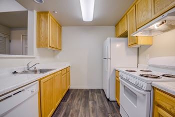 A kitchen with white appliances and wooden cabinets