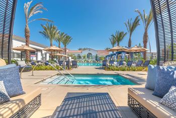 A resort style swimming pool with lounge chairs and umbrellas