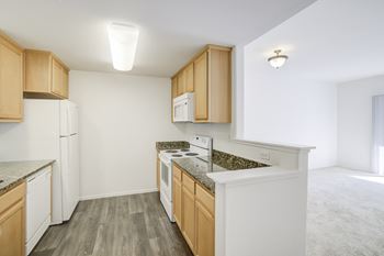 A kitchen with wood cabinets and granite countertops
