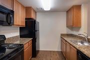 Danville apartment for rent - Kitchen with wooden cabinets and black appliances at Meadow Wood at Alamo Creek, California
