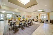 Los Angeles apartment for rent - a resident clubhouse with a long table with chairs and a kitchenette in the background at Tesoro Senior Apartments, Porter Ranch, CA, 91326