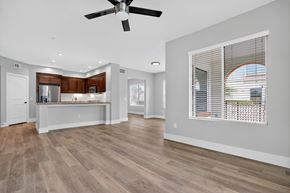 Laguna Woods apartment for rent - A spacious living room with a ceiling fan and hardwood flooring.
