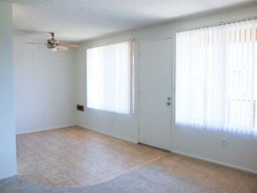 Huntington Beach apartment for rent - a living room with a ceiling fan and two windows