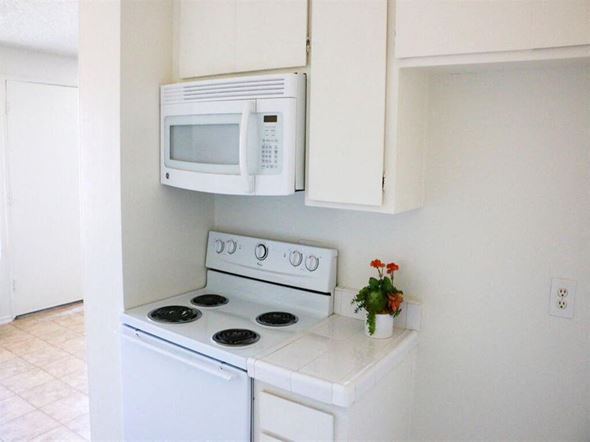 Huntington Beach apartment for rent - a small kitchen with a white stove and microwave