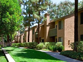 Lake Forest apartment for rent - a row of apartment buildings with green grass and trees