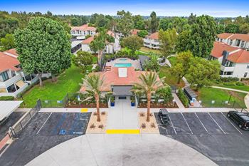 An aerial view of a house with a basketball court and palm trees