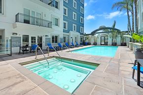 San Diego apartment for rent - a swimming pool with blue chairs and a blue building in the background  at Apex Mission Valley, San Diego, California