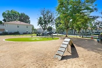 A park with a bench and a grassy area in front of a building