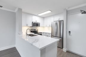 San Diego apartment for rent - A modern kitchen with white countertops and stainless steel appliances.