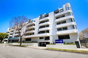 Los Angeles apartment for rent - a white apartment building with a blue sign in front of it at The Kenmore Los Feliz, California