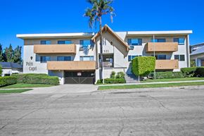 Burbank apartment for rent - a large white building with a palm tree in front of it at Palm Capri Apartments, Burbank, CA, 91501