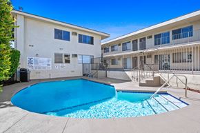 Burbank apartment for rent - our apartments have a large swimming pool and a building with a fence at Palm Capri Apartments, California, 91501