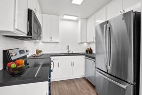 Burbank apartment for rent - a kitchen with white cabinets and stainless steel appliances at Palm Capri Apartments, Burbank, 91501