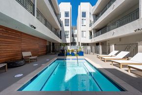 Los Feliz apartment for rent - A swimming pool in a courtyard surrounded by buildings.
