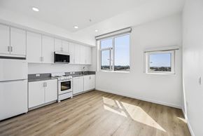 Santa Monica apartment for rent - 711 Colorado sample kitchen with white cabinets and a vinyl floor. Views of Santa Monica city scape.