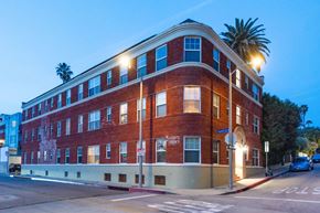 Santa Monica apartment for rent - A red brick building with a palm tree in front of it.