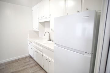 Santa Monica apartment for rent - A white kitchen with a sink and a refrigerator.
