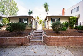 Santa Monica apartment for rent - A residential area with two houses, a tree, and a small garden.