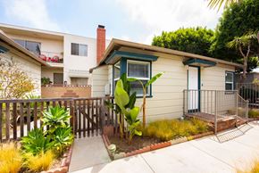Santa Monica apartment for rent - A house with a green window and a red car in the background.