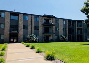 St Cloud apartment for rent - a building with a green lawn and a sidewalk in front of it