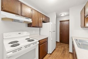 Braham apartment for rent - A kitchen with white appliances and wooden cabinets.