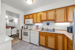 Burnsville townhouse for rent - A kitchen with wooden cabinets and white appliances.