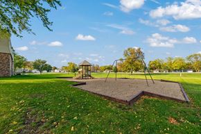 Redwood Falls apartment for rent - A playground with a swing set and a sandbox in the foreground.