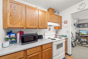 Redwood Falls apartment for rent - A kitchen with wooden cabinets and a white stove top oven.