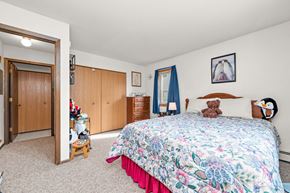 Redwood Falls apartment for rent - A bedroom with a floral bedspread and a teddy bear on the bed.