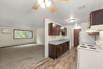 Coon Rapids apartment for rent - A kitchen with a white stove and wooden cabinets.