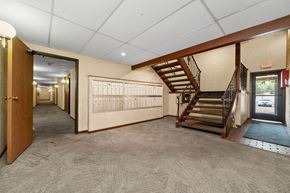 Oakdale apartment for rent - A hallway with a staircase and a calendar on the wall.