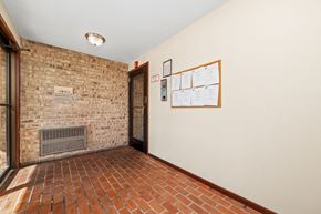 Oakdale apartment for rent - A hallway with a brick wall and a bulletin board on the wall.