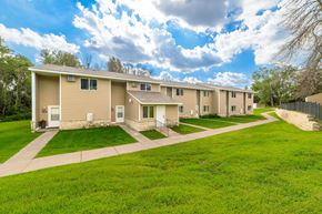 Oakdale townhouse for rent - A row of houses with green lawns in front.