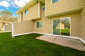 Oakdale townhouse for rent - A house with a tan siding and a green lawn.