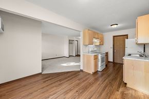 Faribault townhouse for rent - A kitchen with wooden floors and white appliances.