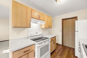 Faribault townhouse for rent - A kitchen with white appliances and wooden cabinets.