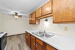 Sandstone apartment for rent - A kitchen with wooden cabinets and a white countertop.