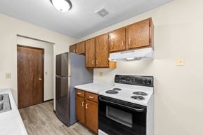 Sandstone apartment for rent - A kitchen with a stove, refrigerator, and cabinets.