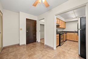 North St Paul apartment for rent - A kitchen with a black fridge and brown flooring.