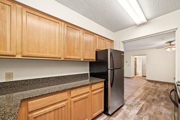 North St Paul apartment for rent - A kitchen with wooden cabinets and a black refrigerator.