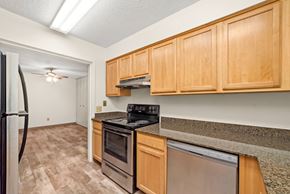North St Paul apartment for rent - A kitchen with wooden cabinets and a black stove top oven.