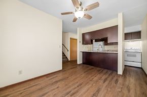 Forest Lake townhouse for rent - A room with a ceiling fan and wooden floors.