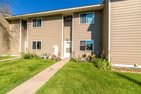 Forest Lake townhouse for rent - A beige house with a white door and windows.